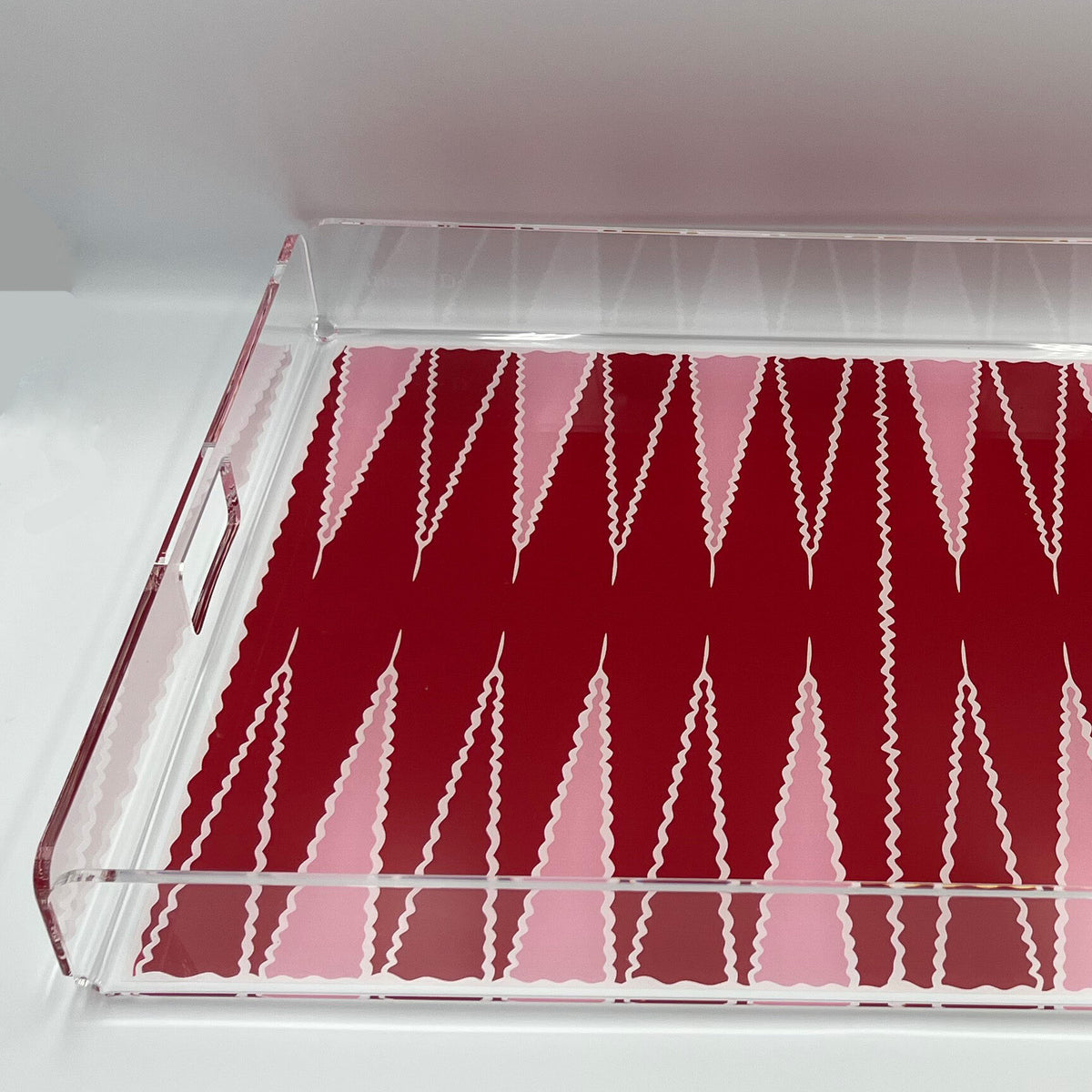Détail du damier rouge et rose d'un plateau de backgammon et de sa bordure en plexi