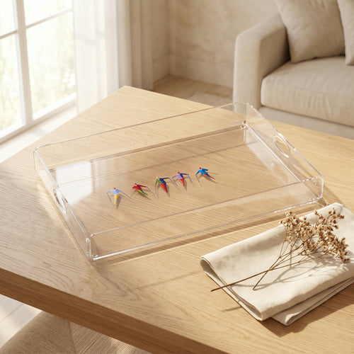 Plateau en plexi imprimé de cinq skieurs colorés en file, posé sur une table en chêne clair avec une serviette en lin et des fleurs séchées